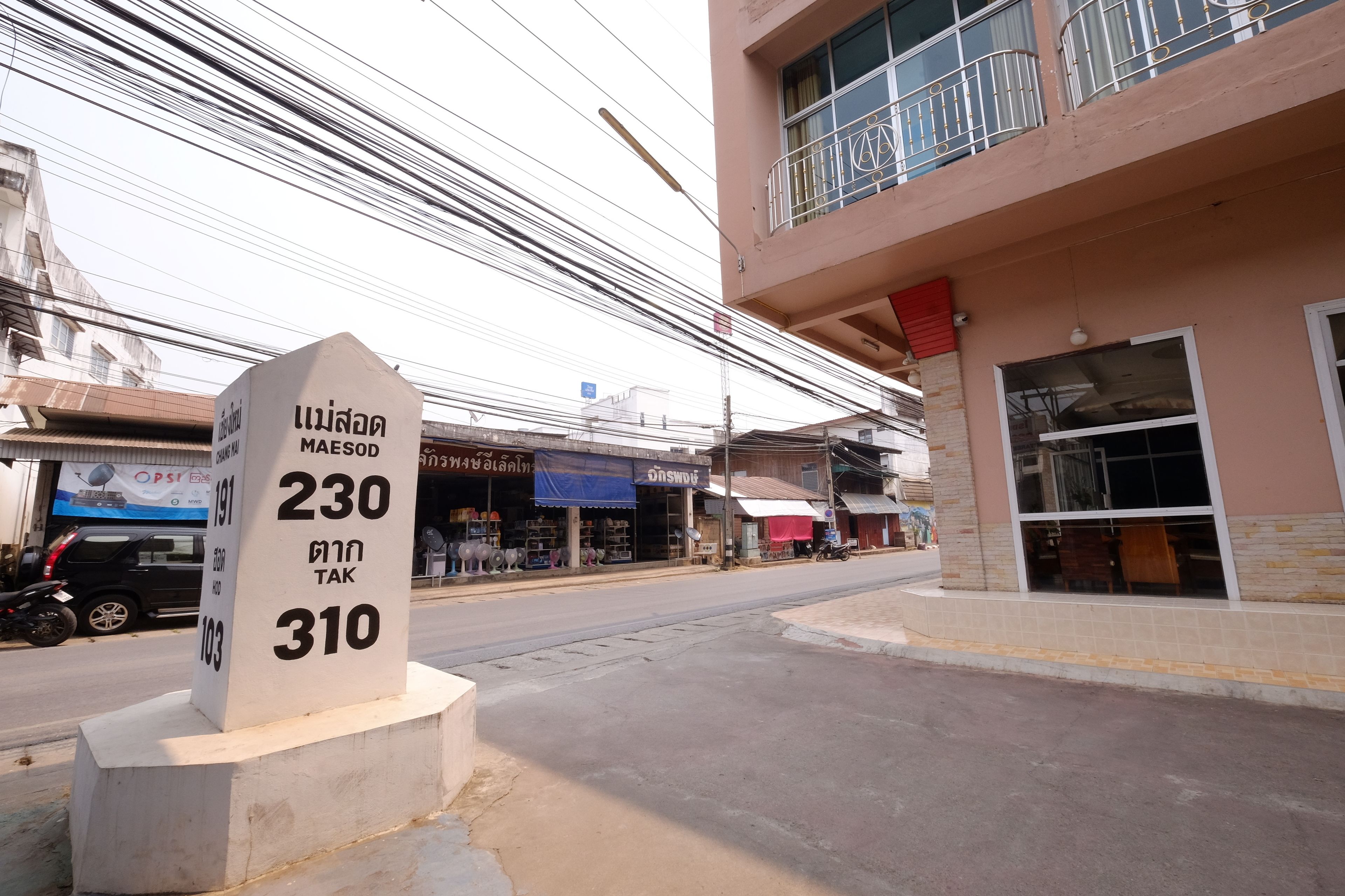 A street sign with Thai text indicating a location.