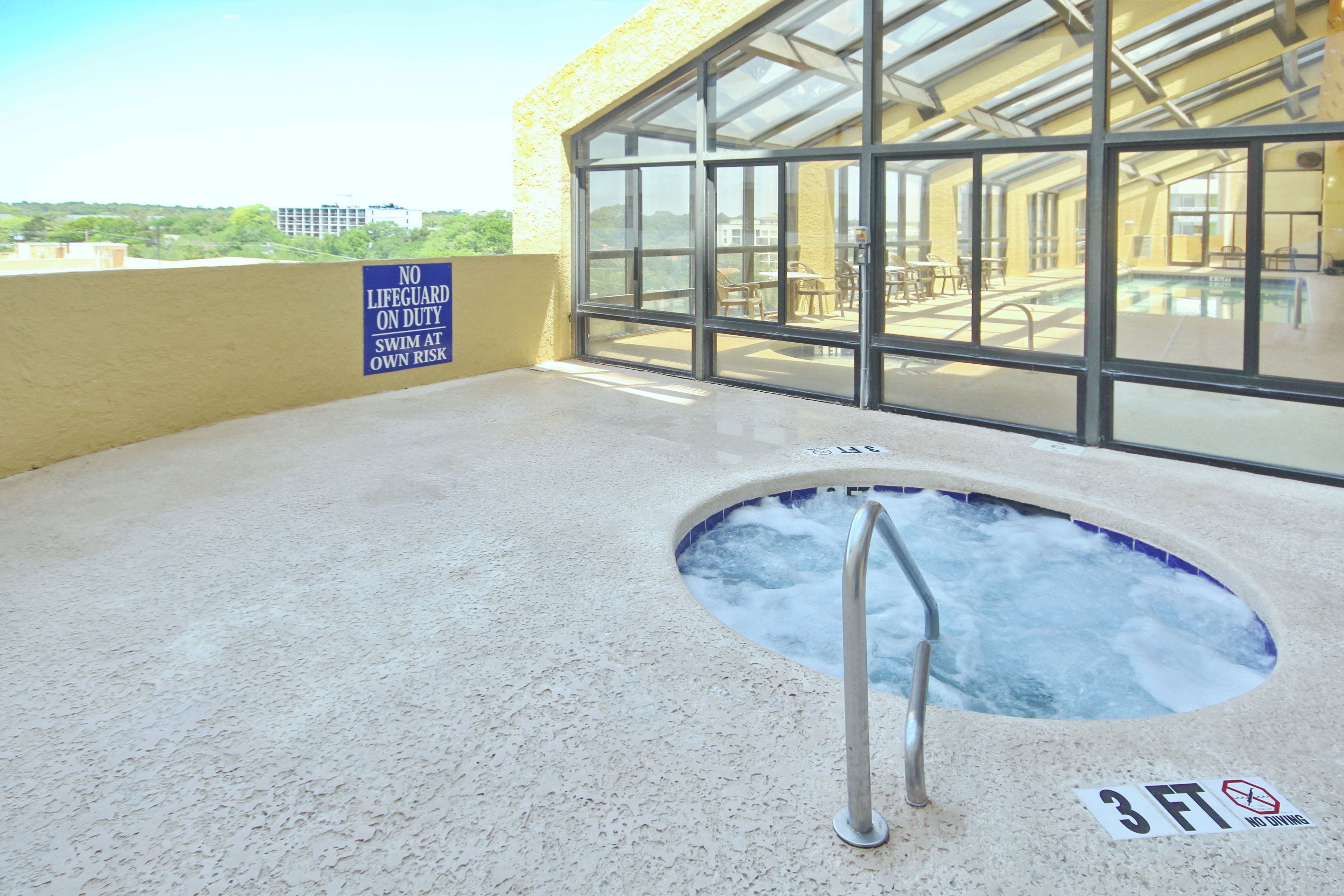 A hot tub with a sign indicating no lifeguard on duty and a 3 ft depth limit.