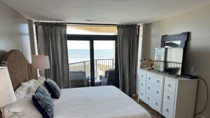A bedroom with a large bed, a dresser, a television, and a view of the ocean. - Lovely Oceanfront Condo with Gorgeous View with 3 Beds\3 Baths (North Myrtle Beach)