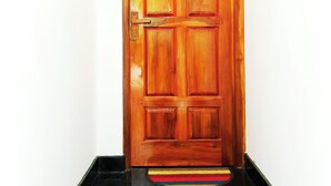 Une porte en bois, dotée d’une poignée en laiton et d’une petite plaque décorative en bas.