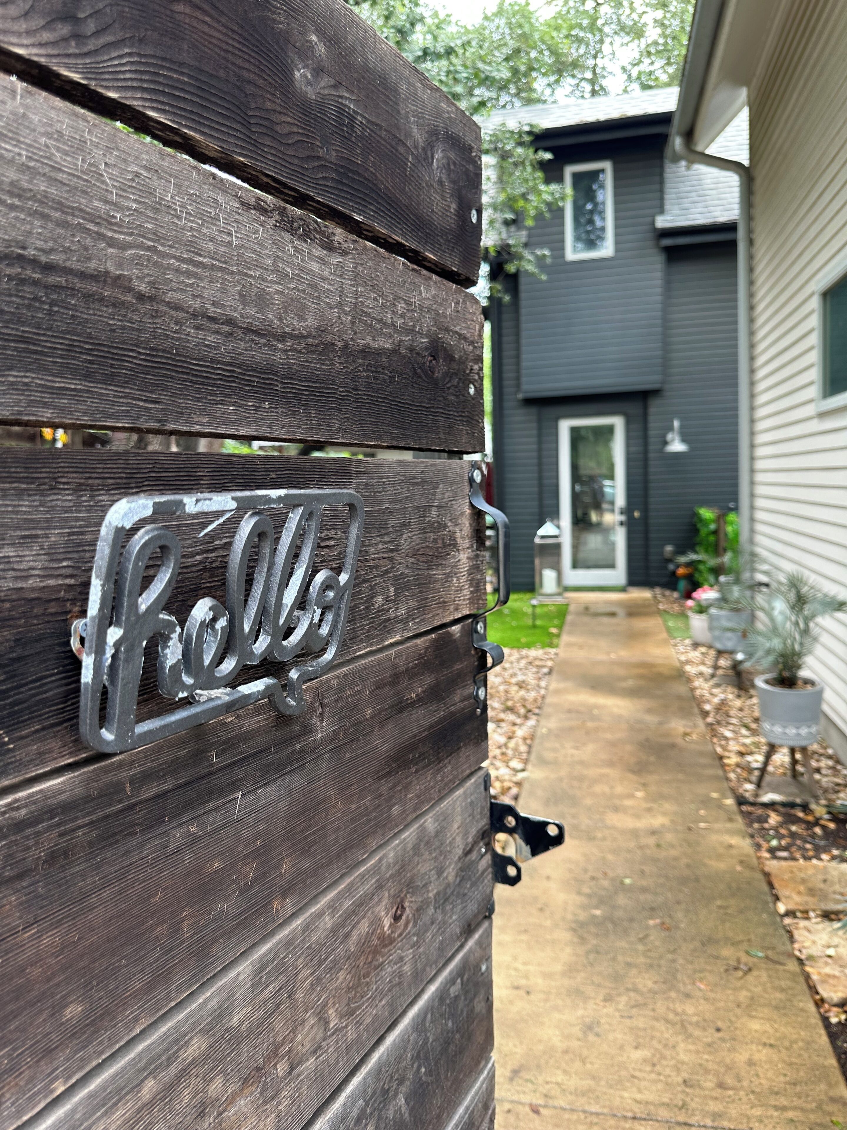 A wooden gate with a metal nameplate reading 'Rolls.'