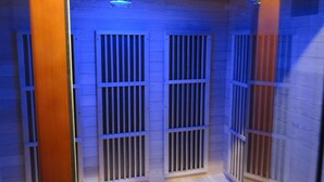 Una habitación con paredes de paneles de madera, suelo de madera y techo con una lámpara fluorescente.