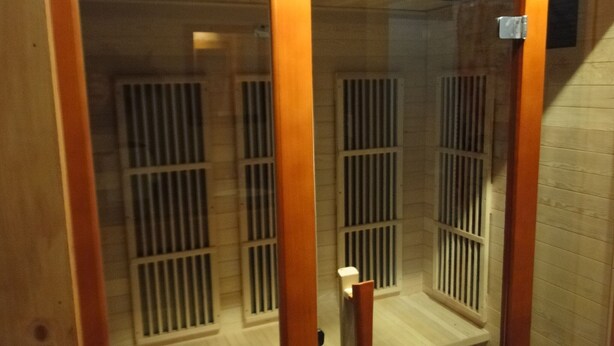Una sala de sauna con listones de madera y un banco.
