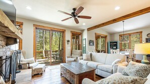 A spacious living room with a wooden coffee table, a sofa, and a ceiling fan.