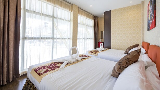A hotel room with two beds, large windows, a ceiling fan, and a painting on the wall. - Hamilton Hotel Kajang (Kajang)