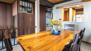 A wooden dining table with chairs, a vase with flowers, and a wooden bench. - Star Harbor # 04 by Hauserman Rentals (Tahoe City)