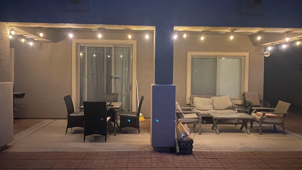 An outdoor patio area with seating and tables, string lights, and a refrigerator. - Beautiful home in quiet neighborhood (Casa Grande)