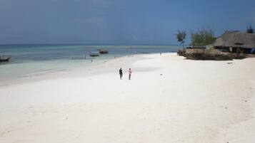 On the beach, white sand, sun loungers, beach umbrellas