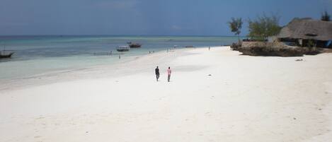 Am Strand, weißer Sandstrand, Liegestühle, Sonnenschirme