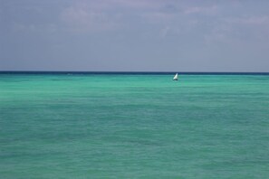 Am Strand, weißer Sandstrand, Liegestühle, Sonnenschirme