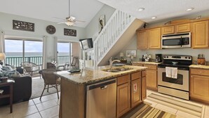 A kitchen with granite countertops, stainless steel appliances, wooden cabinets, and a view of the ocean. - 34- Great place for FAMILIES in this quaint 3 story condo! Coral Reef Club (Destin)