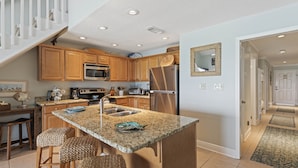 A modern kitchen with wooden cabinets, granite countertops, and stainless steel appliances. - 34- Great place for FAMILIES in this quaint 3 story condo! Coral Reef Club (Destin)