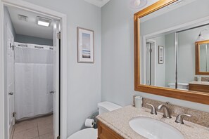 A bathroom with a sink, mirror, and toilet.