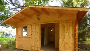 A wooden cabin with a sloped roof, a door, and a window.