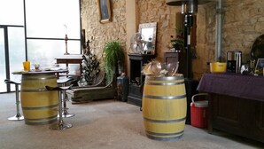 A rustic interior with wooden furniture, a stone wall, and a fireplace. - Le Clos des Aramons (Bernis)