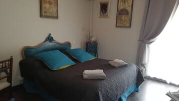 Ein Schlafzimmer mit einem Bett, einem Nachttisch und einem Fenster mit Vorhängen.