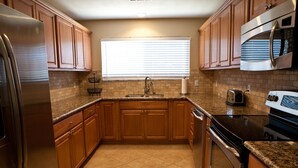 A kitchen with wooden cabinets, a stainless steel refrigerator, a microwave, and a stove. - Direct Lake Front Paradise Cove #1 In Reviews - Beach - Launch - Traeger Smoker (Clearlake)
