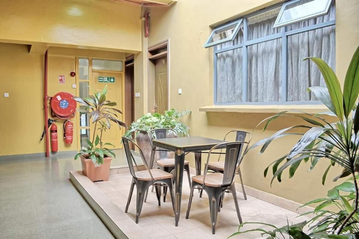 A dining area with a table and chairs, potted plants, and a fire extinguisher.