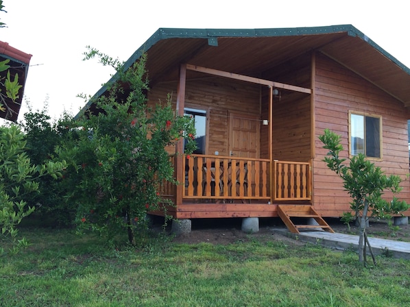 A wooden cabin with a balcony, surrounded by greenery. - Yildiz Pension Bungalows (Kemer)