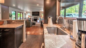 Una cocina moderna con una isla grande, estufa integrada y un amplio ventanal con vistas al exterior.