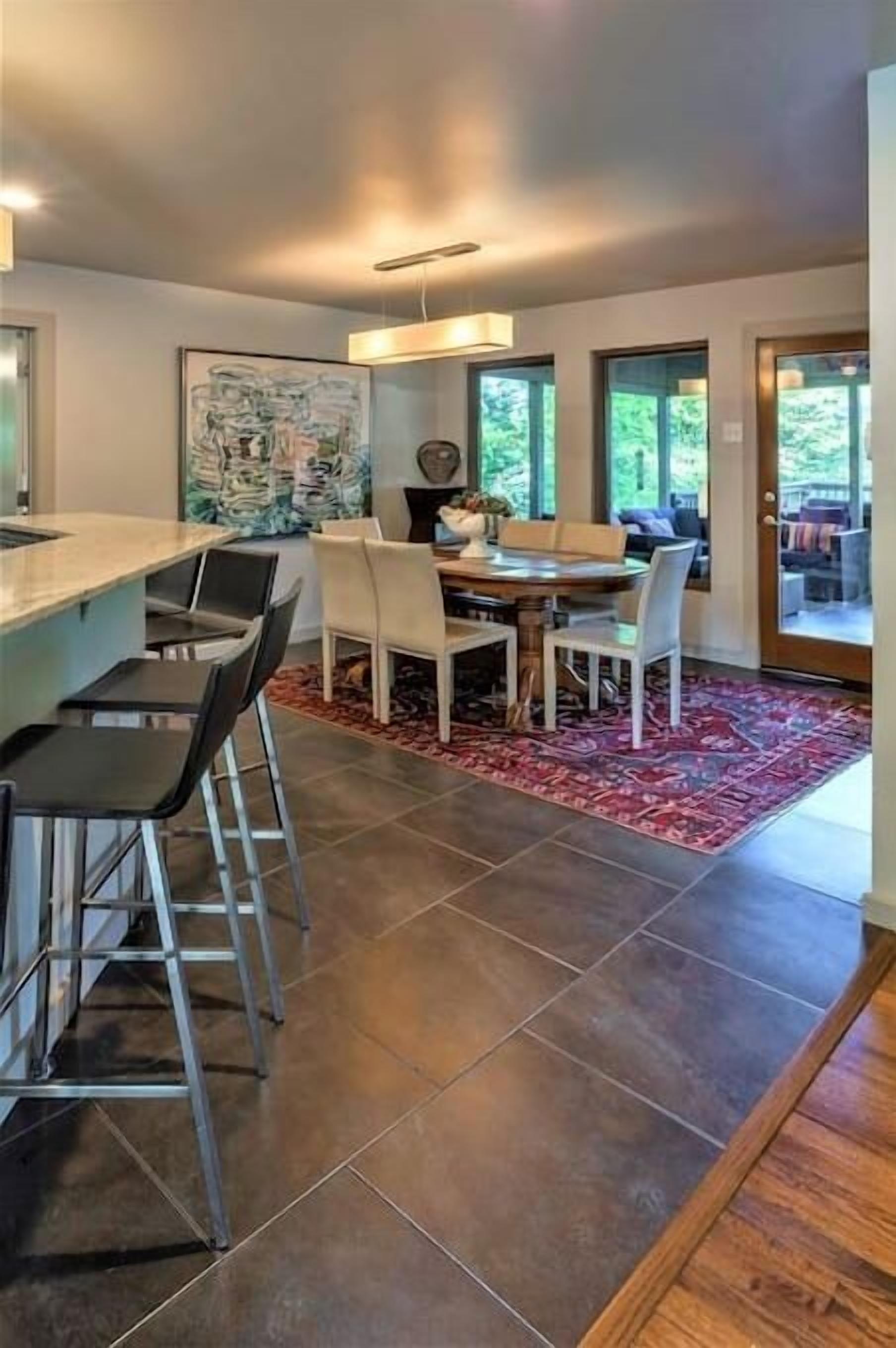 Une cuisine moderne avec un coin bar, une table à manger et des chaises.