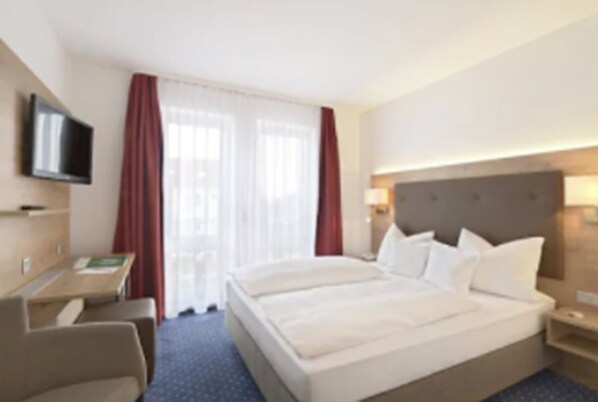 A hotel room with a large bed, a desk, a chair, a flat-screen TV, and a window with curtains. - Hotel Poinger Hof (Poing)