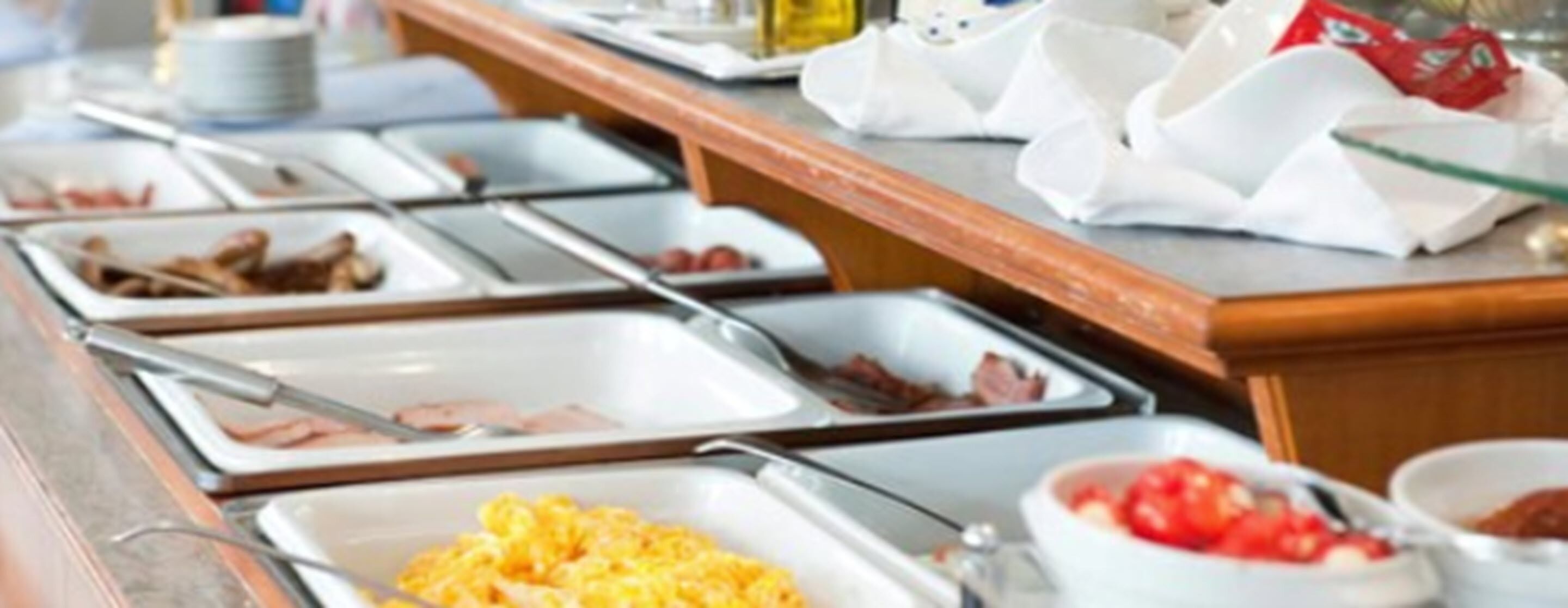 A buffet with various food options including meats, eggs, and vegetables.