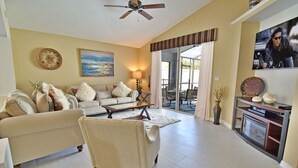 A living room with a sofa, armchair, and a fireplace. - Beautiful Pool Home With Kid's Play Room - Close to Theme Parks & Attractions (Kissimmee)