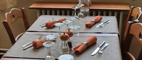 A dining table set for four with a view of greenery outside.
