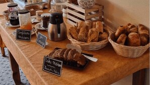 Um buffet de café da manhã com diversos alimentos e acompanhamentos.