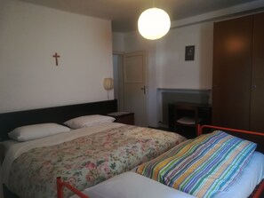 A bedroom with a bed, a chair, a wardrobe, and a wall-mounted light fixture. - Hotel Roen Ruffrè-Mendola (Ruffre)
