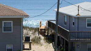 A beachfront property with a wooden deck, a sandy path leading to the beach, and a view of the ocean. - Callalily | Gorgeous Ocean Views in Topsail Beach! (Topsail Beach)
