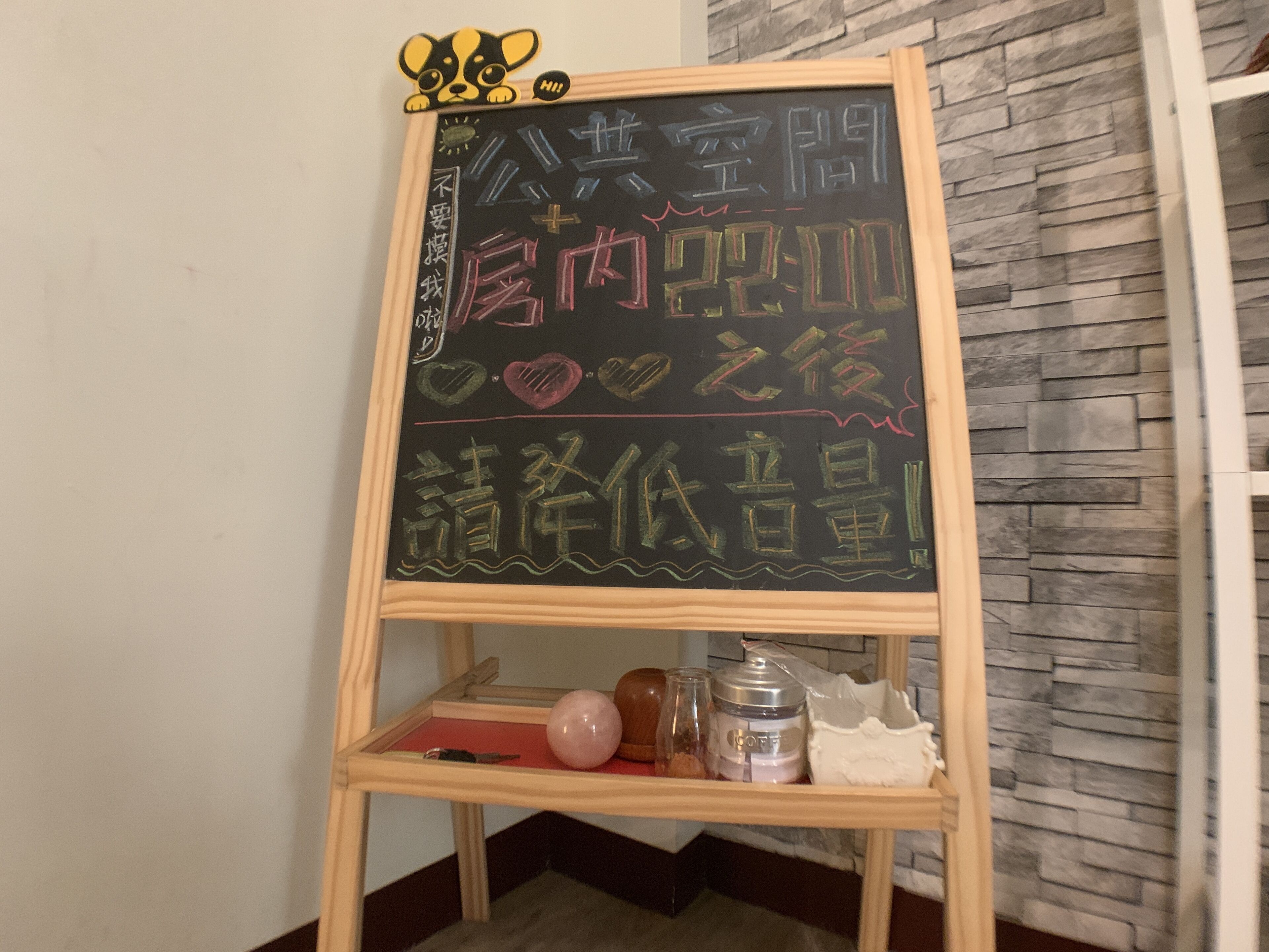 A blackboard with Chinese characters, a wooden stand, and a stone wall background.