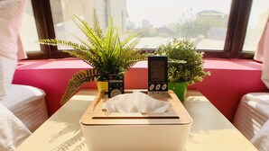 A room with a wooden table, a tissue box, a remote control, and two potted plants. - Partyport-Hai (Tainan)