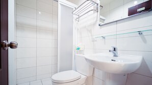 A bathroom with a white toilet, a sink, and a shower area. - Partyport-Hai (Tainan)