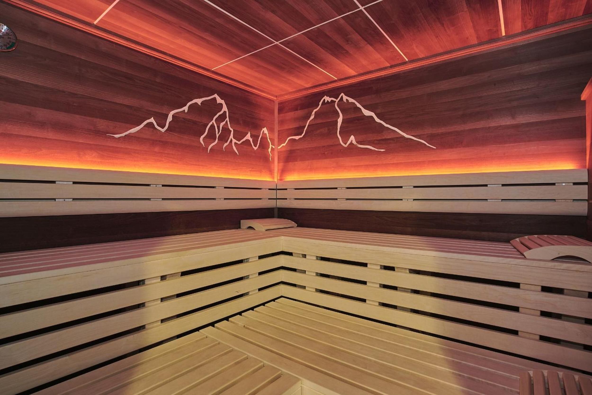 A sauna with wooden benches and a red-lit ceiling.