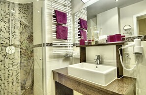 A modern bathroom with a glass-enclosed shower, a white sink, and a vanity with a mirror. - Hotel Neuhäusl Berchtesgaden (Berchtesgaden)