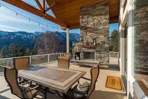 An outdoor patio with a stone fireplace, a table, and chairs. - asy Lake Days & Big Views — Across from Willow Point Park (Manson)