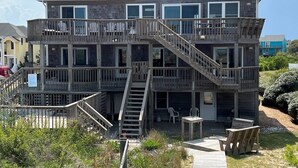 A multi-story building with a wooden exterior, a balcony on the second floor, and a staircase leading to the upper levels.