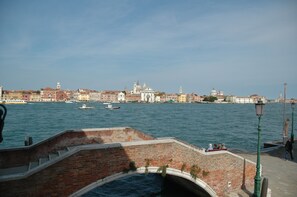 Un canal con barcos, un puente y edificios históricos al fondo.