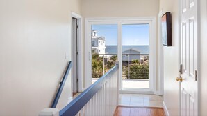 Un couloir donnant sur un balcon et l’océan.