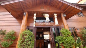 A wooden guest house with a sign reading "The good view" and a covered entrance.
