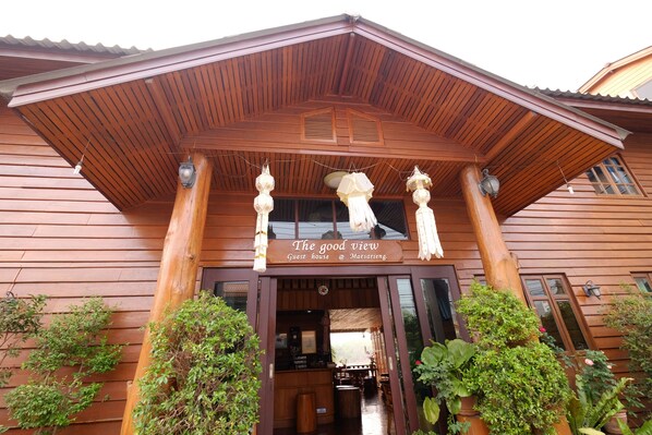 A wooden guest house with a sign reading "The good view" and a covered entrance.