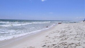 Ein Strand mit blauem Himmel und ruhigem Wasser.