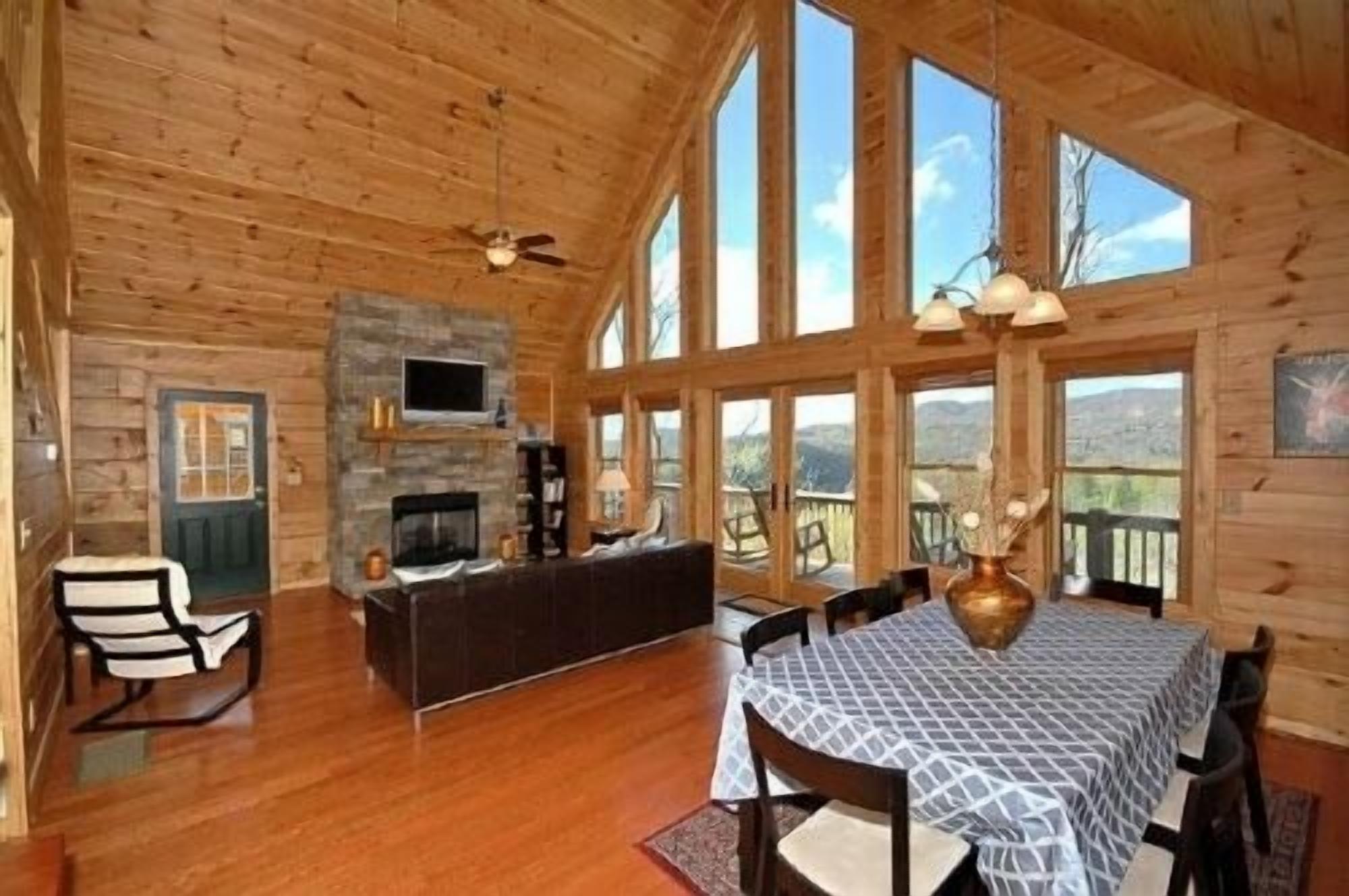 Une cabine spacieuse dotée d’une cheminée, d’un téléviseur fixé au mur et d’un coin repas avec une table et des chaises.
