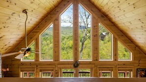 A wooden interior with a high ceiling, large windows, and a ceiling fan. - Skylands by Carolina Mornings | Hot Tub + Biltmore Pass 8 mins to Hatley Pointe (Mars Hill)