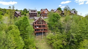 A cluster of wooden cabins on a hillside, surrounded by dense forest. - Skylands by Carolina Mornings | Hot Tub + Biltmore Pass 8 mins to Hatley Pointe (Mars Hill)