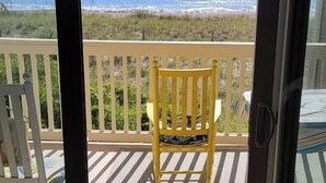 A balcony with a view of the ocean and beach.