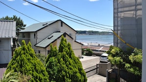 Un edificio residencial con vista al mar, rodeado de vegetación y líneas eléctricas.
