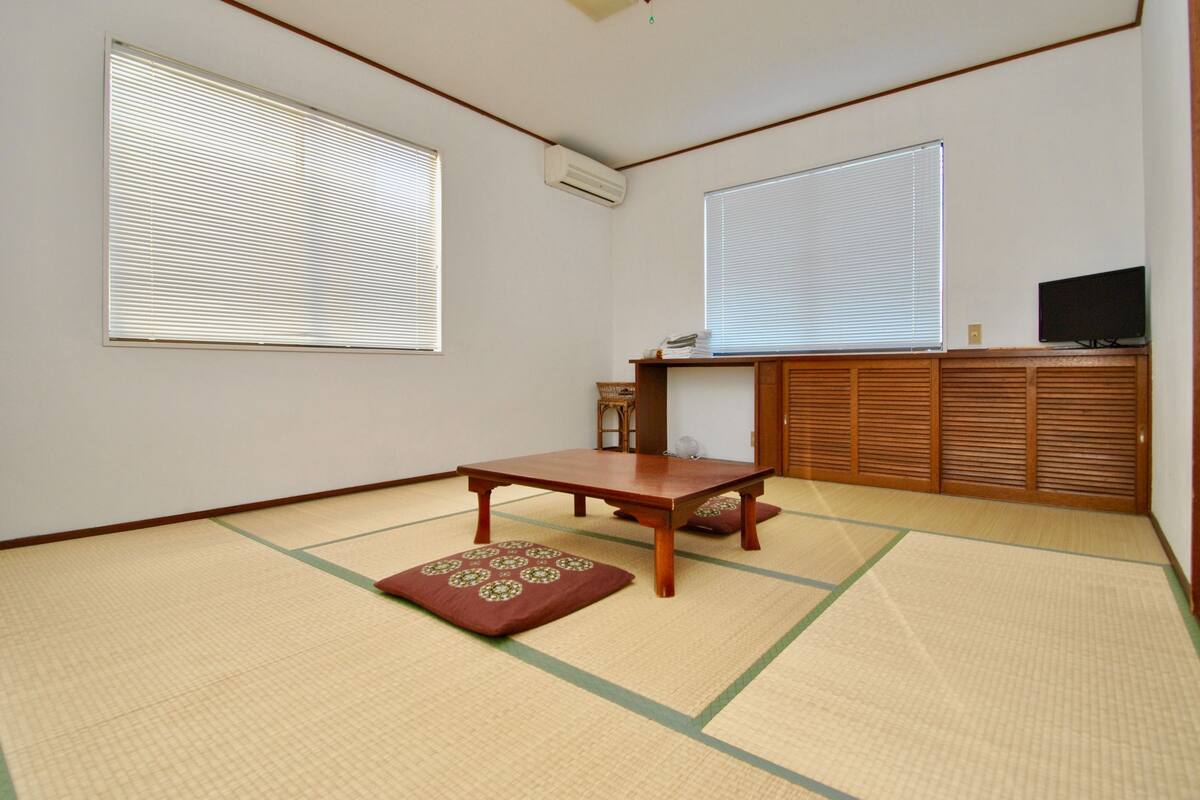 A traditional Japanese room with tatami flooring, a low wooden table, and sliding shoji doors.
